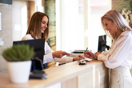 A customer services team member greets a visitor